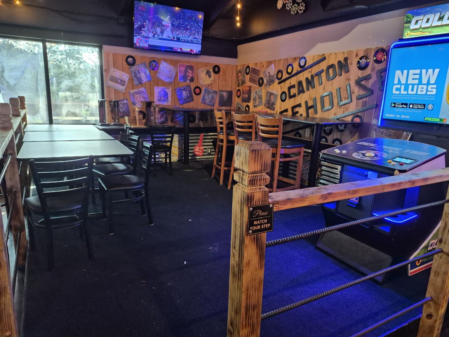 Canton Icehouse game corner with pool tables, arcade games and the venue name on the wood wall.